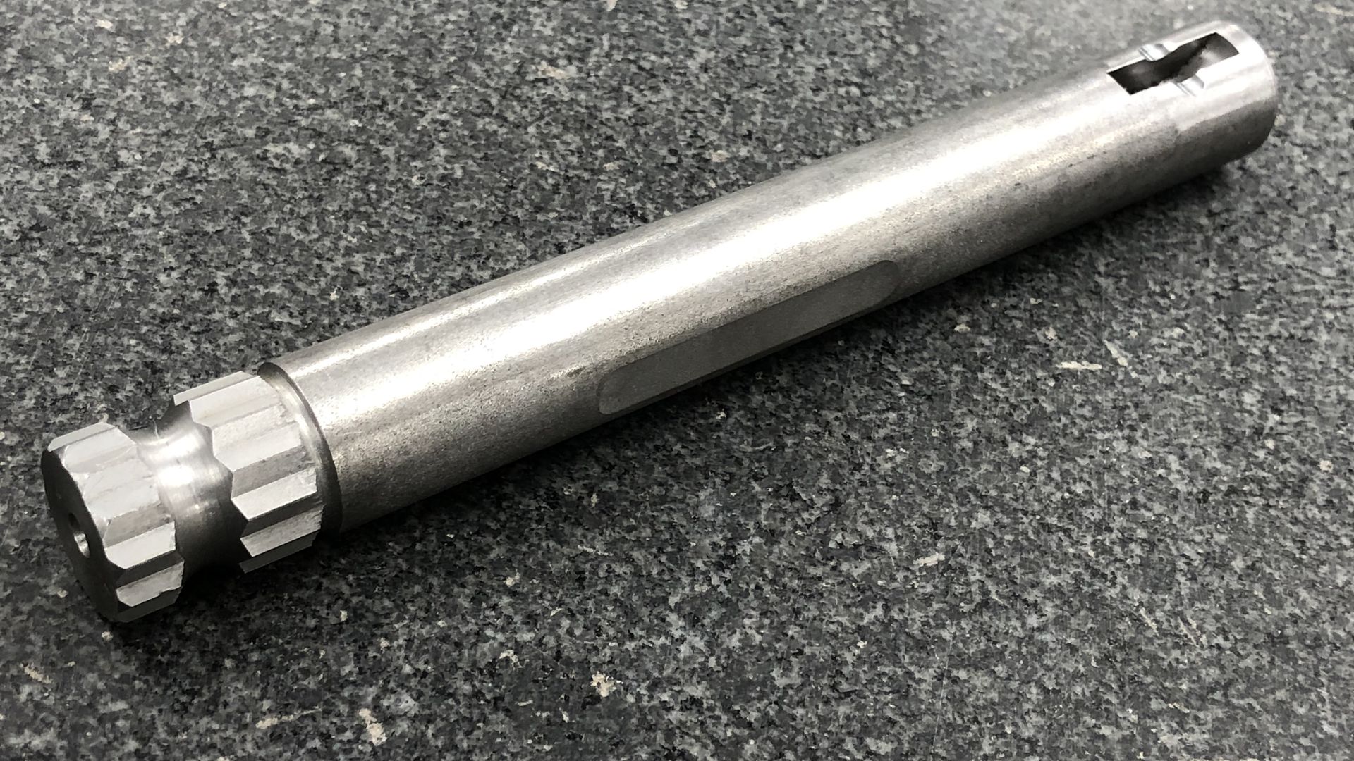 Machined heavy truck clutch shaft with an external spline, a milled flat and a cross slot